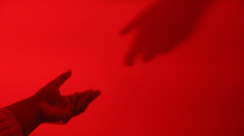 Still of a hand reaching a shadow from Ari